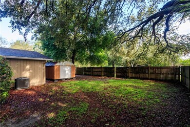 Fenced backyard with double gate and storage shed