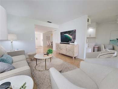 Living room with ceiling fan and light tile patter