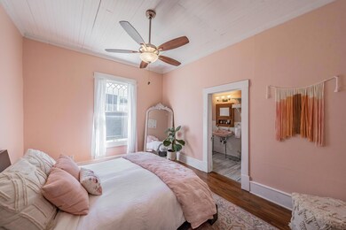 Bedroom with hardwood floors, ceiling fan, ornamen