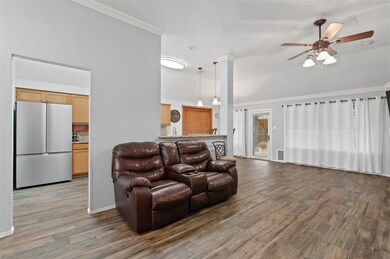 Living area with crown molding, light wood-style f