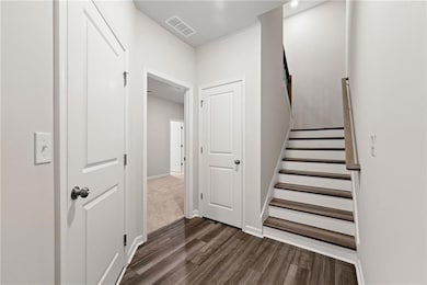 Staircase featuring dark carpet