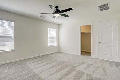 Spacious master bedroom with carpet floors and lar