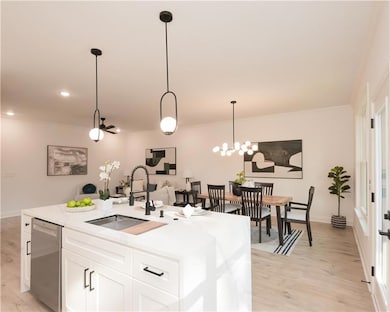 Kitchen with white cabinetry, light wood-type flooring, light stone counters, a chandelier, and dishwasher