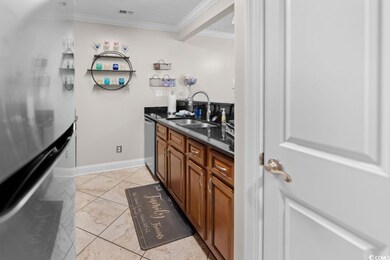 Kitchen featuring crown molding, sink, and stainle