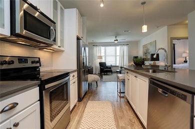 Kitchen featuring white cabinetry, tasteful backsp