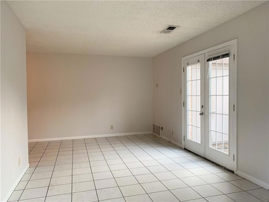 Spare room featuring baseboards, french doors, vi