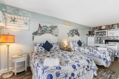 Bedroom featuring dark wood-style flooring and freestanding refrigerator