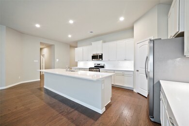 The kitchen also features tons of storage space in the custom cabinetry, lovely white countertops as well as stainless appliances.