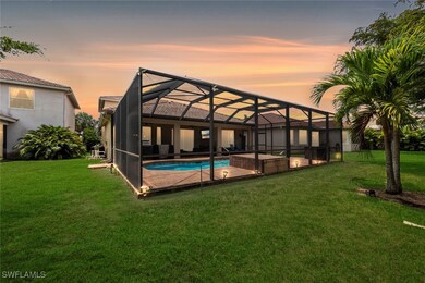 Back of house at dusk with an outdoor pool, a yard