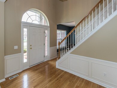 Let the sunshine in!  Cheerful, inviting 2-story Foyer with lovely crown molding and chairs&squares moldings and pretty hardwood floors.