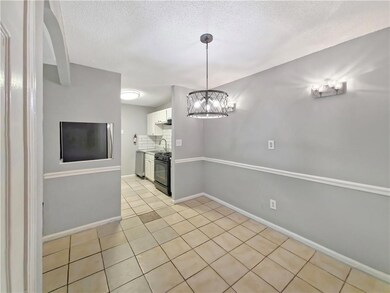 Unfurnished dining area featuring a textured ceiling, a chandelier, and light tile patterned floors