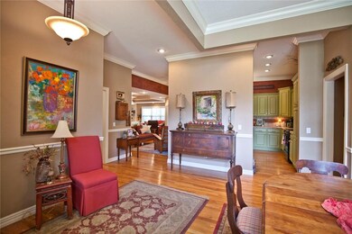 Beautiful hardwood floors lead to kitchen and living area