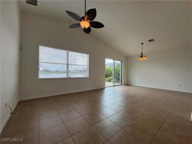 Spare room featuring light tile patterned floors, ceiling fan, and high vaulted ceiling