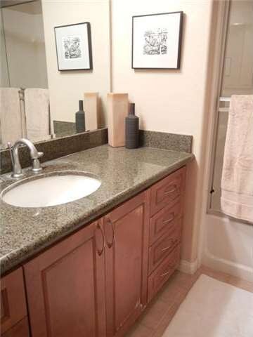 : Bathroom has granite counter top and ceramic flo