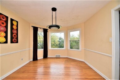 Dining room with wood flooring and walk in bay win