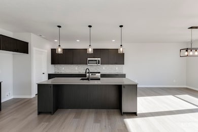Kitchen with decorative backsplash, pendant lighting, an island with sink, modern cabinets, and recessed lighting