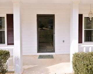 Doorway to property with covered porch