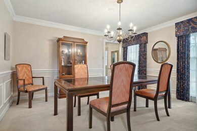 Dining area with light carpet, ornamental molding,