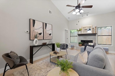 Living area featuring a fireplace, a ceiling fan,