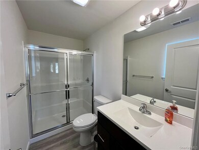 Bathroom with vanity, toilet, a shower with door, and hardwood / wood-style floors