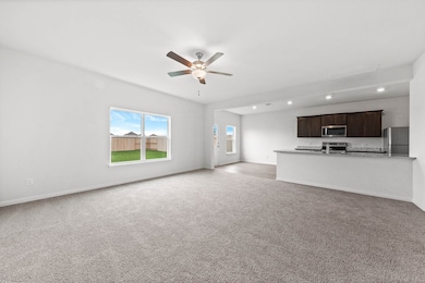 Unfurnished living room featuring light carpet, a ceiling fan, and recessed lighting
