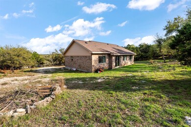 Rear view of property featuring a lawn and brick 
