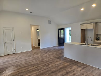 Unfurnished living room with lofted ceiling, recessed lighting, and dark wood-style floors