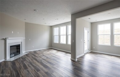 Unfurnished living room with a high end fireplace, dark wood finished floors, healthy amount of natural light, and a textured ceiling