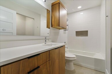 Bathroom featuring toilet, vanity, and shower / b