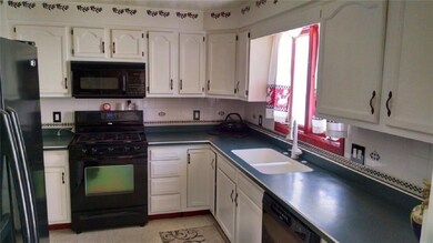 ANOTHER VIEW OF THE BRIGHT KITCHEN.
