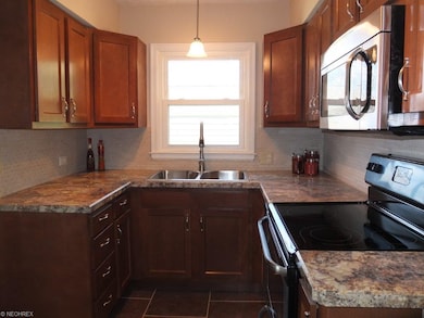 Remodeled kitchen with pantry and tile floor.