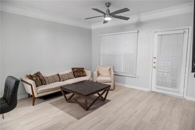 Living room featuring crown molding, light hardwoo