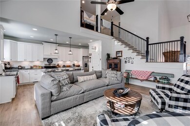 Living room featuring a towering ceiling, light wo