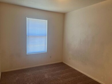 Empty room featuring dark carpet and baseboards