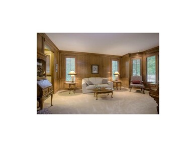 A WARM AND INVITING LIVING ROOM WITH CURVED WINDOW