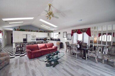 Living room featuring light hardwood / wood-style flooring, ceiling fan, and vaulted ceiling