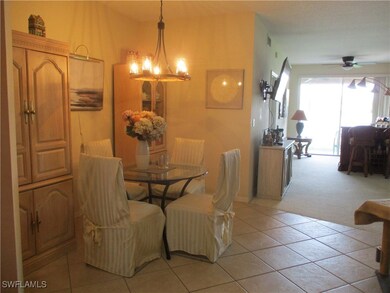 Tiled dining space with ceiling fan with notable chandelier