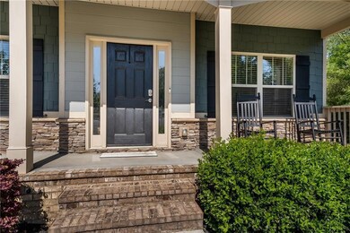 Doorway to property featuring a porch and stone siding