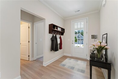 Entrance foyer with crown molding and light wood-t