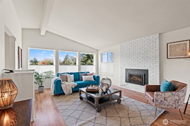 Living room with vaulted ceiling and fireplace.