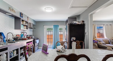 Dining area with plenty of natural light, wood finished floors, and attic access