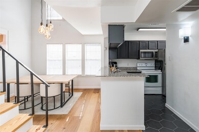 Kitchen with hanging light fixtures, light stone c