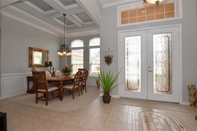 Entry with mosaic tile and dining room with crown 