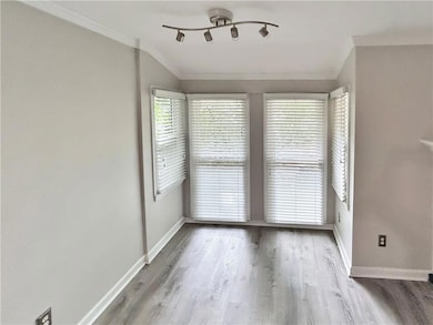 Unfurnished room with crown molding and wood finished floors