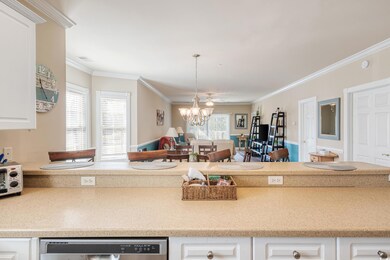 Kitchen with white cabinetry, a chandelier, dishwa