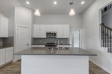 Kitchen has loads of storage with ample cabinets and a pantry.