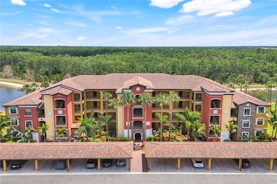 View of property with covered parking and a wooded view