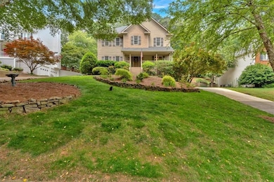 Traditional home featuring a front yard and concrete driveway