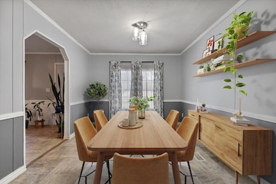 Dining space with arched walkways, crown molding, and a textured ceiling