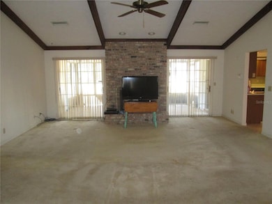 Living room with wood burning fireplace and double sliders to large screened covered patio